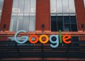 Colorful Google logo on modern building exterior in urban environment.