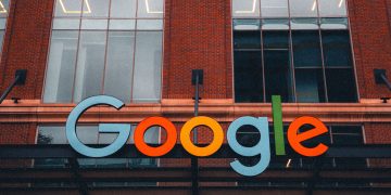 Colorful Google logo on modern building exterior in urban environment.
