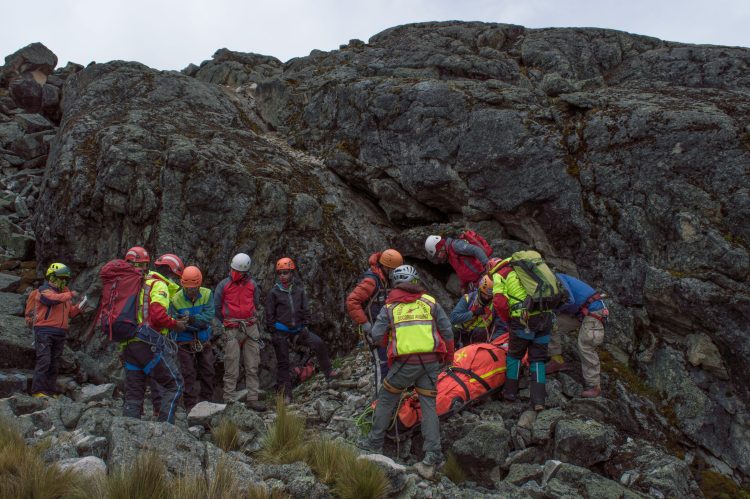 A rescue team aids an injured hiker on a rocky mountain slope during daylight. Speleologo intrappolato in una grotta in Sardegna, soccorritori al lavoro da ore