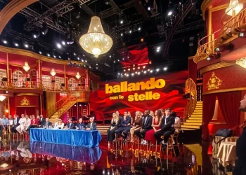 Palco Ballando con le Stelle con giudici e concorrenti seduti, luci brillanti.