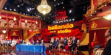 Palco Ballando con le Stelle con giudici e concorrenti seduti, luci brillanti.