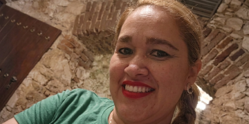 Donna bionda sorridente in maglietta verde davanti a muro in pietra. Milano, l’ergastolo a Pablo Gonzalez Rivas per aver ucciso la compagna Jhoanna Quintanilla