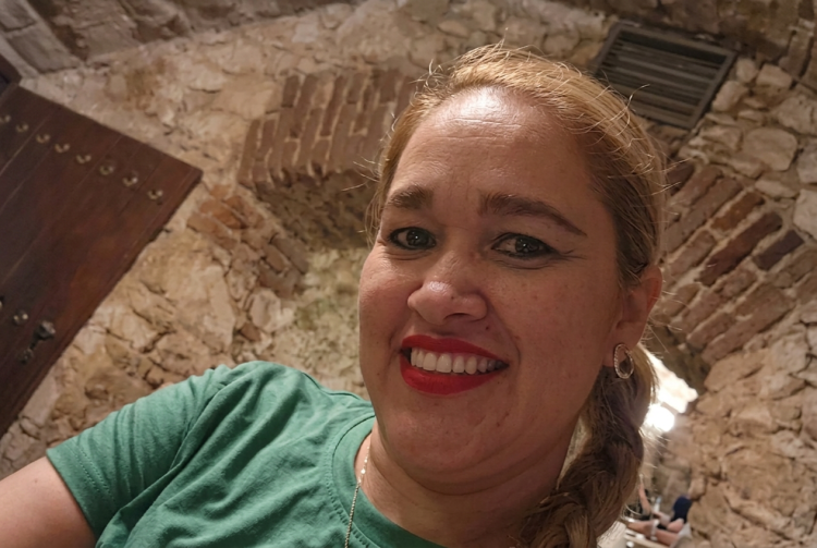 Donna bionda sorridente in maglietta verde davanti a muro in pietra. Milano, l’ergastolo a Pablo Gonzalez Rivas per aver ucciso la compagna Jhoanna Quintanilla