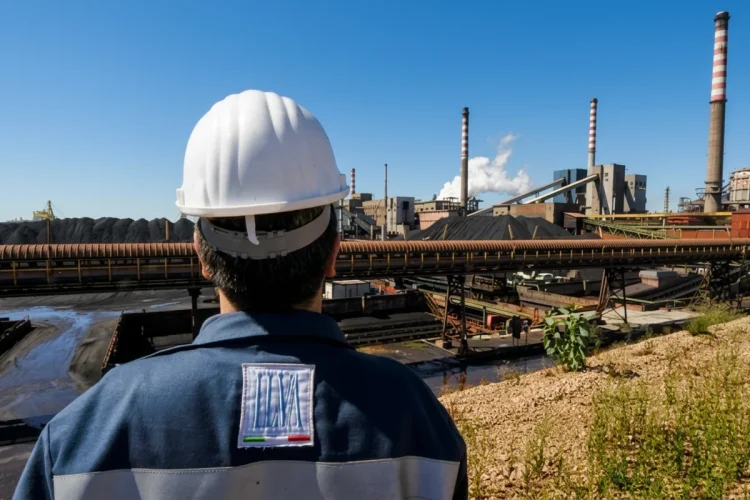Operaio ILVA osserva lo stabilimento siderurgico di Taranto