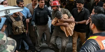 Soccorritore porta in salvo un bambino dopo crollo scuola in Pakistan