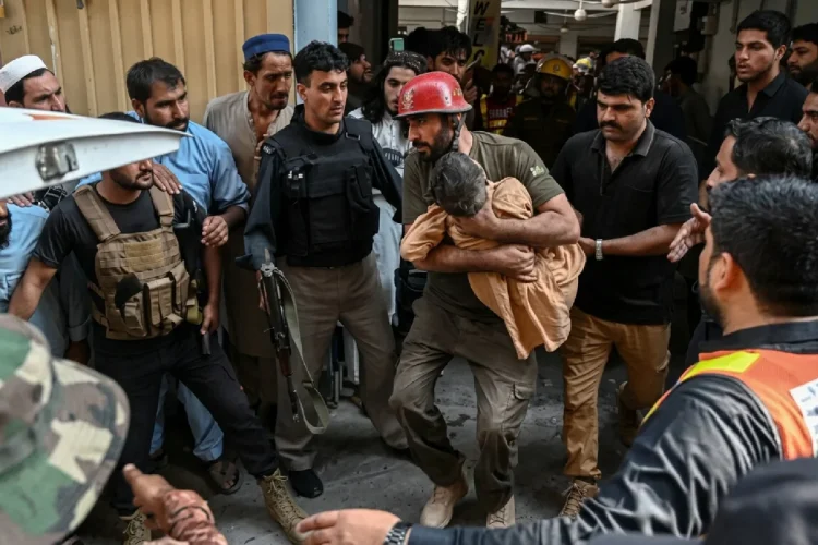 Soccorritore porta in salvo un bambino dopo crollo scuola in Pakistan