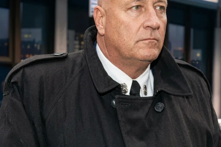 Ritratto in primo piano di Silvano Larini, con sguardo serio, in cappotto scuro.