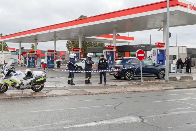 Agenti di polizia delimitano una stazione di servizio con nastro segnaletico. Francia, un uomo apre il fuoco a Trappes: un morto e quattro feriti. Lecornu: "Fatti gravi"