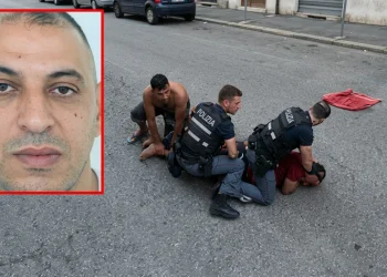 Fakir in primo piano e tre uomini con agenti di polizia a terra