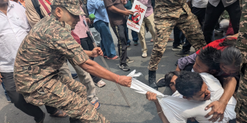 Poliziotto tira maglietta di un manifestante durante protesta a Nuova Delhi. New Delhi, il Partito delle blatte torna in piazza: rilasciati i leader