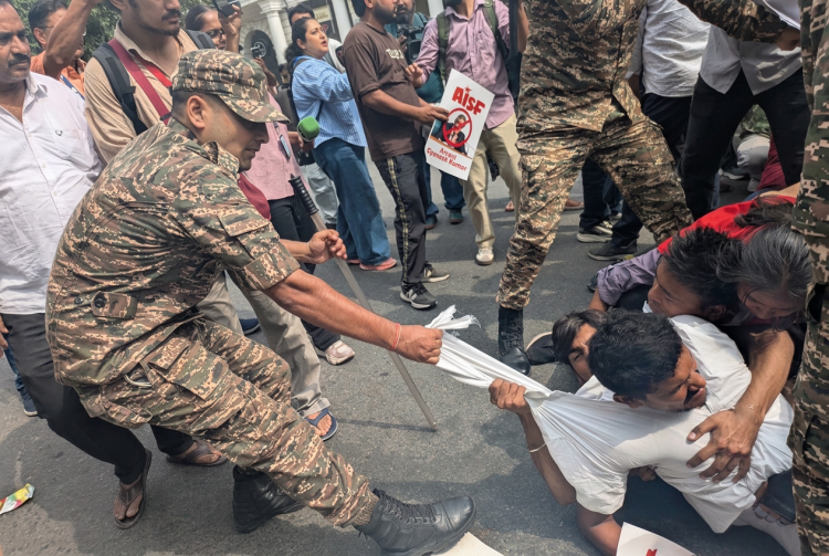 Poliziotto tira maglietta di un manifestante durante protesta a Nuova Delhi. New Delhi, il Partito delle blatte torna in piazza: rilasciati i leader