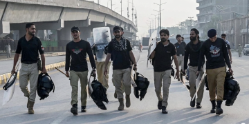 Agenti di polizia pakistani con scudi antisommossa su strada urbana. Pakistan, approvato lo stato d'emergenza: il presidente Zardari affida al governatore la provincia