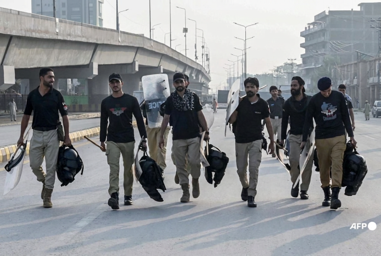 Agenti di polizia pakistani con scudi antisommossa su strada urbana. Pakistan, approvato lo stato d'emergenza: il presidente Zardari affida al governatore la provincia