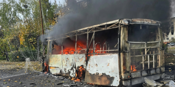 Autobus in fiamme dopo un raid a Kramatorsk, fumo nero visibile.