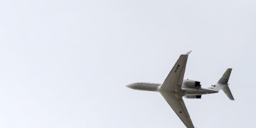 Aereo a reazione bianco in volo visto dal basso in cielo chiaro. Usa, aereo sanitario disperso: trovati detriti, 6 persone ancora ricercate al largo del Massachusetts