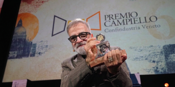 Marcello Fois con barba e occhiali sorride alzando il Premio Campiello. La giuria del Campiello premia Marcello Fois: la dedica a Murgia e il ricordo di Deledda