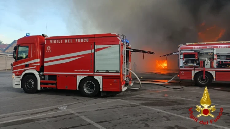 Camion dei Vigili del Fuoco estinguono un incendio in capannone a Napoli.
