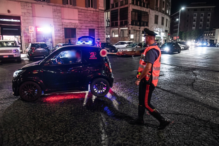 Carabiniere in strada ferma piccola auto nera con luci lampeggianti. Banda delle minicar, il minorenne a Pm e carabinieri: "Era uno scherzo"