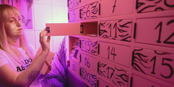 Donna bionda apre cassetto numerato di un armadietto rosa a Varsavia. Le attiviste inaugurano a Varsavia il primo distributore di pillole abortive della Polonia