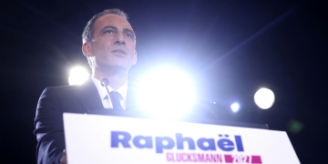 Raphaël Glucksmann parla al podio in un evento politico notturno. Francia, Glucksmann ottiene la candidatura all'Eliseo al primo turno