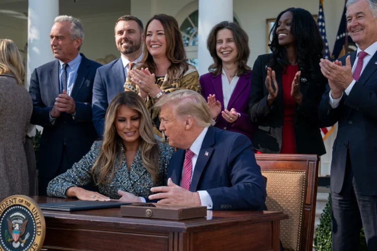 Donald Trump parla con Melania Trump seduti a una scrivania presidenziale