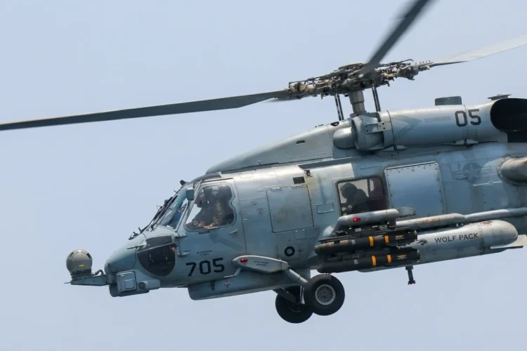 Elicottero militare grigio con missili in volo, pattugliamento aereo
