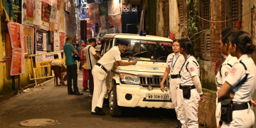 Agenti di polizia e veicolo dei servizi di emergenza in strada a Kolkata. India, almeno 19 morti nella calca per l'acquazzone durante un festival indù